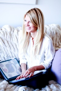 A woman sitting on the couch with her laptop